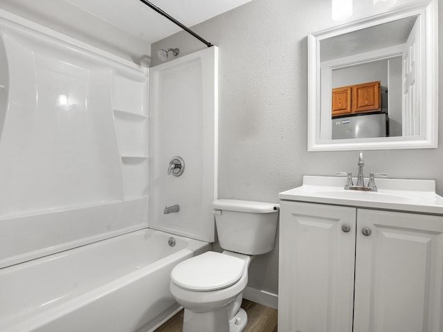 full bathroom featuring toilet, vanity, wood finished floors, tub / shower combination, and a textured wall