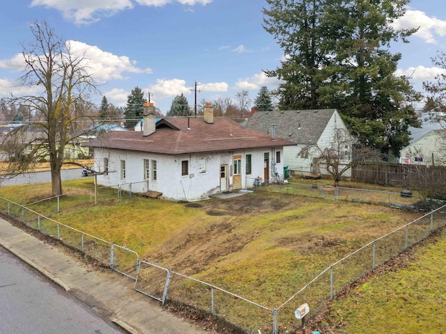 back of house with a lawn, fence, and a chimney