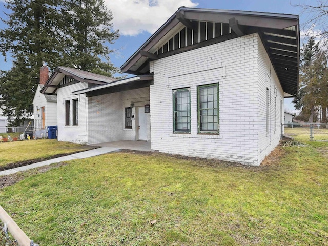 view of front of house featuring a front yard, fence, and brick siding