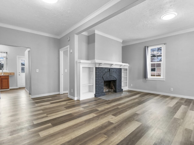 unfurnished living room with a textured ceiling, a fireplace, wood finished floors, and ornamental molding