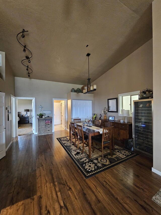 21319 E Harvard Vistas Ln, Newman Lake, WA 99025 - dining area featuring dark wood finished floors, baseboards, high vaulted ceiling, and track lighting