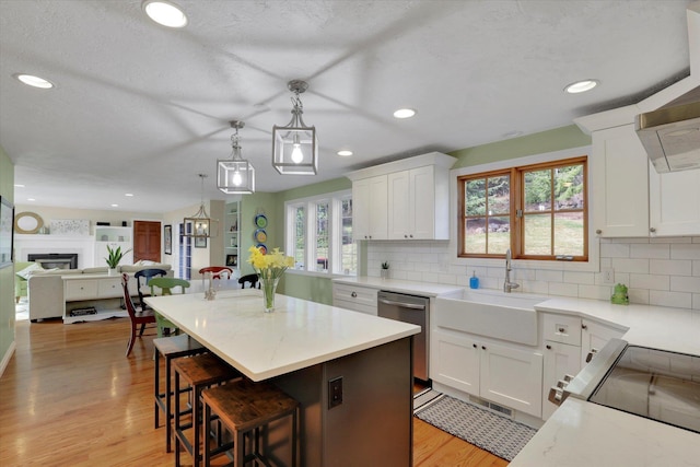 6814 S Jackson Ridge Ln, Greenacres, WA 99016 - kitchen featuring dishwasher, a sink, open floor plan, decorative backsplash, and light wood-type flooring