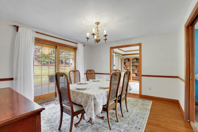 6814 S Jackson Ridge Ln, Greenacres, WA 99016 - dining room featuring a chandelier, light wood-style floors, and baseboards