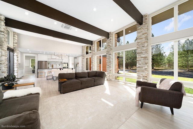 27809 N Bruce Rd, Chattaroy, WA 99003 - living room featuring light wood-style flooring, beamed ceiling, a high ceiling, and visible vents