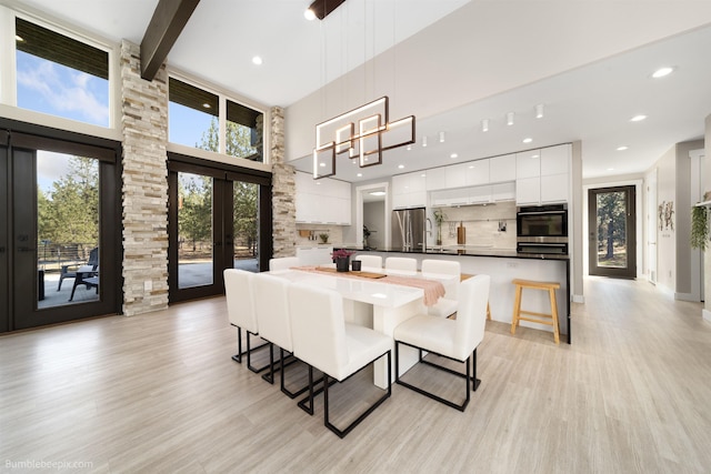 27809 N Bruce Rd, Chattaroy, WA 99003 - dining room featuring beam ceiling, french doors, light wood finished floors, a high ceiling, and recessed lighting