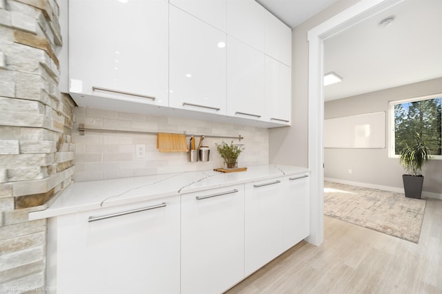 27809 N Bruce Rd, Chattaroy, WA 99003 - kitchen with white cabinetry, modern cabinets, light wood-style floors, and light stone counters