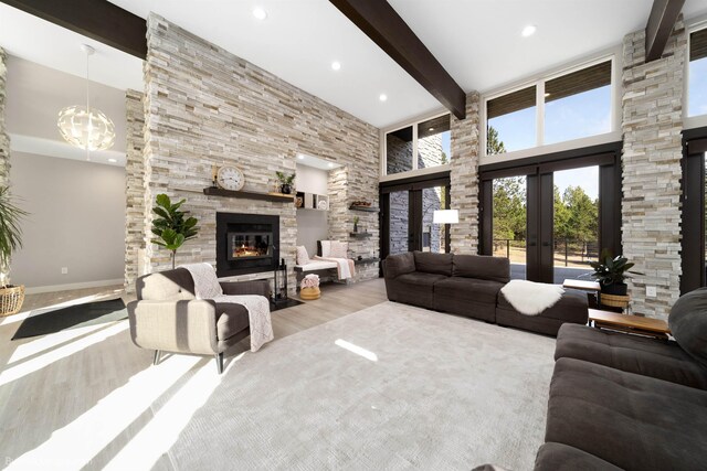 27809 N Bruce Rd, Chattaroy, WA 99003 - living room with french doors, a high ceiling, beam ceiling, a stone fireplace, and wood finished floors