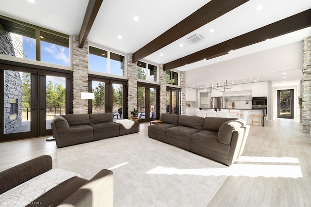 27809 N Bruce Rd, Chattaroy, WA 99003 - living area featuring french doors, light wood-type flooring, visible vents, beamed ceiling, and a towering ceiling