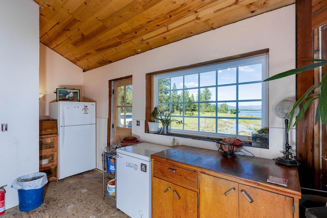 4004P N Northport Flat Creek Rd, Northport, WA 99157 - kitchen with freestanding refrigerator, dark countertops, wood ceiling, brown cabinets, and vaulted ceiling