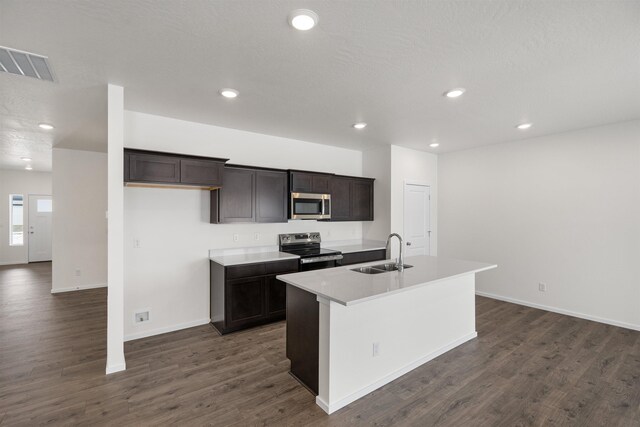 805 E 5th St, Deer Park, WA 99006 - kitchen featuring recessed lighting, dark wood-style flooring, stainless steel appliances, a sink, and a kitchen island with sink