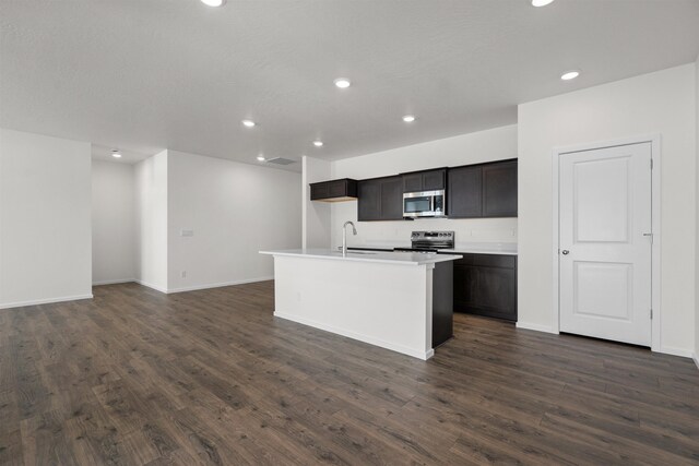 805 E 5th St, Deer Park, WA 99006 - kitchen featuring a center island with sink, a sink, appliances with stainless steel finishes, and dark wood-type flooring