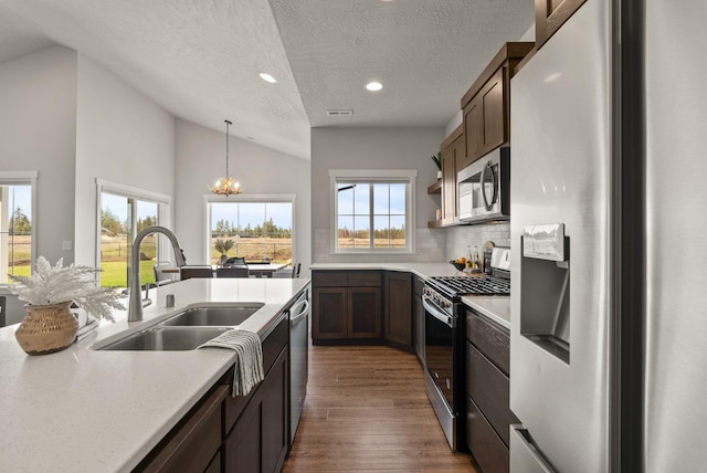 kitchen featuring stainless steel appliances, visible vents, light countertops, and a center island with sink