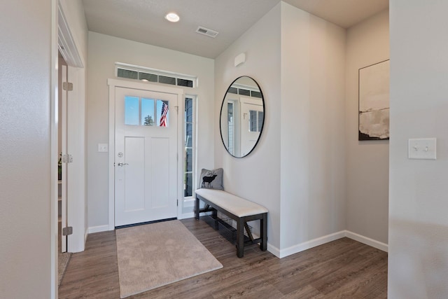 entryway with visible vents, baseboards, and wood finished floors