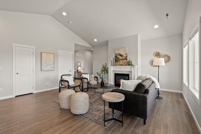 living room featuring high vaulted ceiling, an inviting chandelier, visible vents, wood finished floors, and baseboards