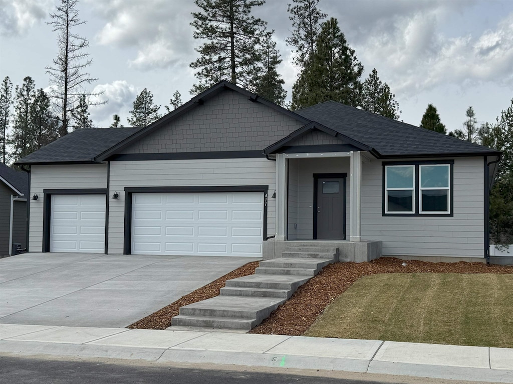 single story home featuring driveway, a garage, and roof with shingles
