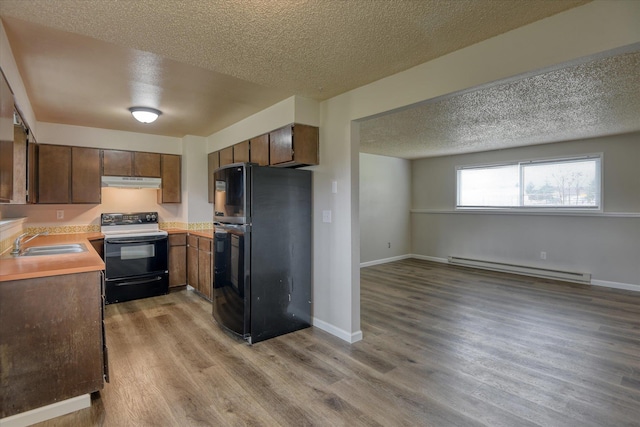 4718 N Campbell Rd, Otis Orchards, WA 99027 - kitchen featuring freestanding refrigerator, range with electric cooktop, under cabinet range hood, a sink, and a baseboard heating unit