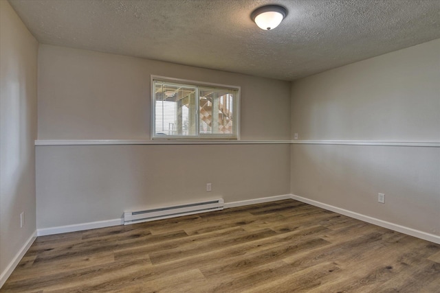 4718 N Campbell Rd, Otis Orchards, WA 99027 - spare room featuring baseboard heating, wood finished floors, a textured ceiling, and baseboards