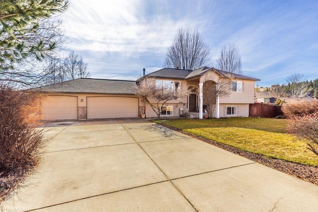 view of front facade with fence, a garage, a front lawn, and driveway