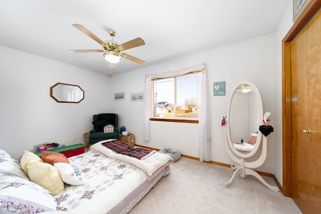 carpeted bedroom featuring baseboards and a ceiling fan