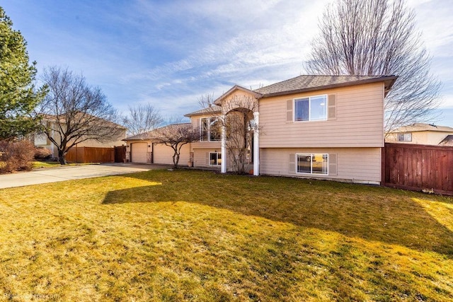 view of front of house featuring a front lawn, driveway, fence, and a garage
