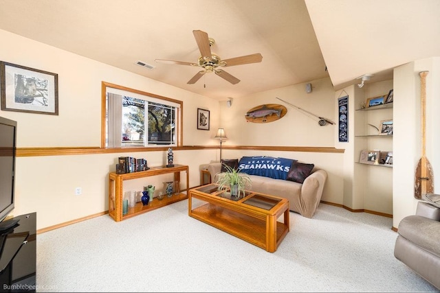 living area featuring visible vents, baseboards, a ceiling fan, and carpet floors