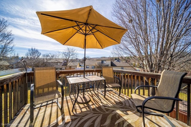 deck with outdoor dining area and a residential view