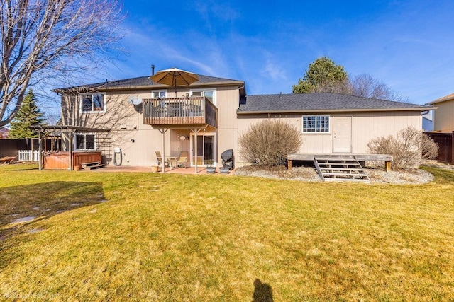 back of property with a yard, a patio area, a hot tub, and fence