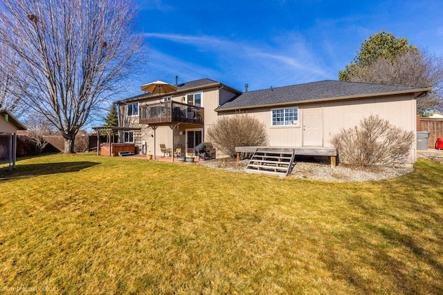 back of house featuring a hot tub, a patio area, a deck, fence, and a lawn