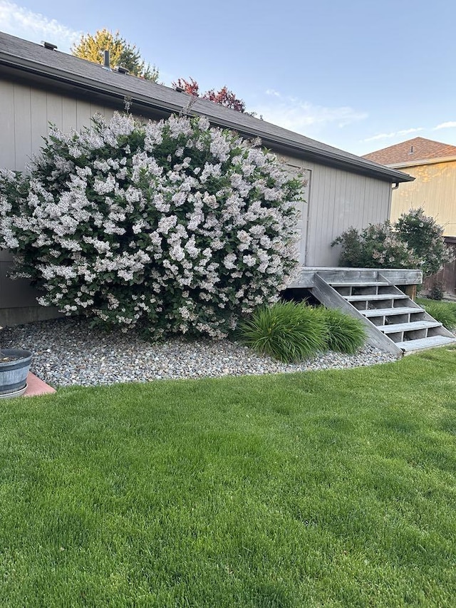 view of side of home with a yard