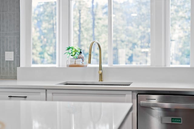 14505 W Coulee Hite Rd, Spokane, WA 99224 - interior details with white cabinetry, light countertops, a sink, and stainless steel dishwasher