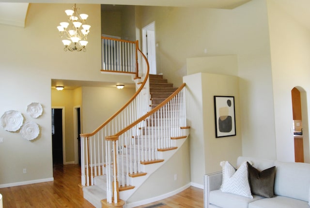 612 N Madson Ct, Liberty Lake, WA 99019 - staircase featuring a high ceiling, baseboards, a chandelier, and wood finished floors