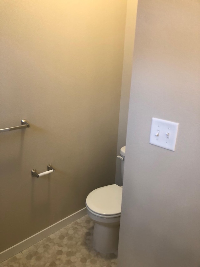 bathroom with baseboards and toilet