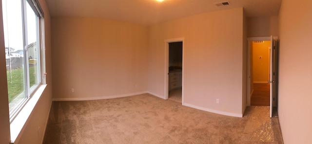 carpeted empty room with baseboards and visible vents