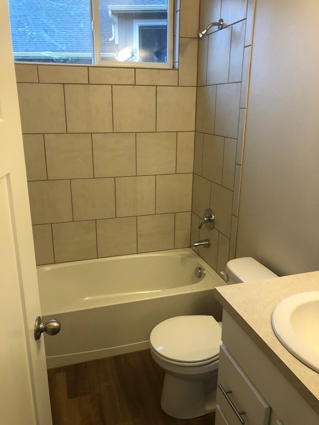 full bath with bathtub / shower combination, toilet, vanity, and wood finished floors