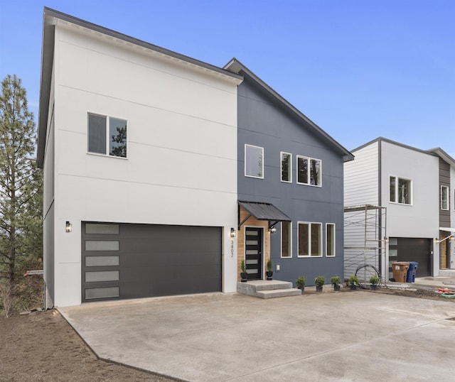 contemporary home featuring concrete driveway, stucco siding, and an attached garage