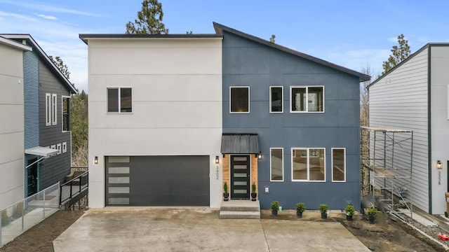 contemporary house with stucco siding, driveway, fence, and a garage