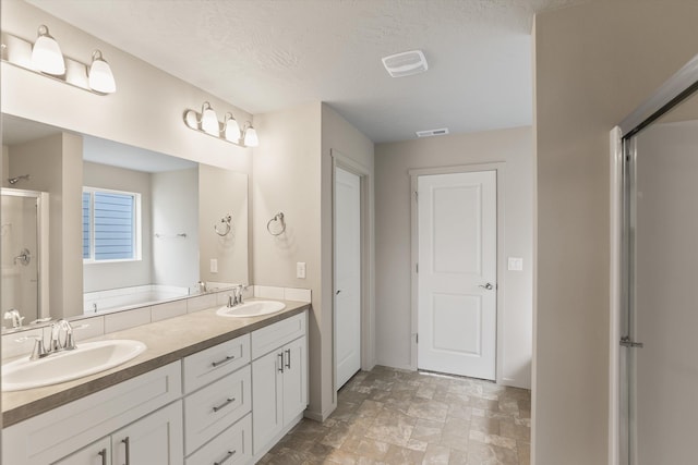 503 N Arc Ct, Spokane Valley, WA 99016 - full bathroom with a shower stall, double vanity, stone finish flooring, and a textured ceiling