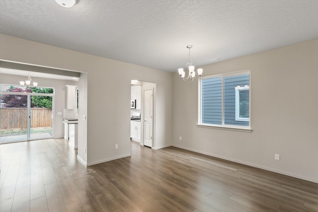 503 N Arc Ct, Spokane Valley, WA 99016 - spare room with a chandelier, dark wood-type flooring, and a textured ceiling