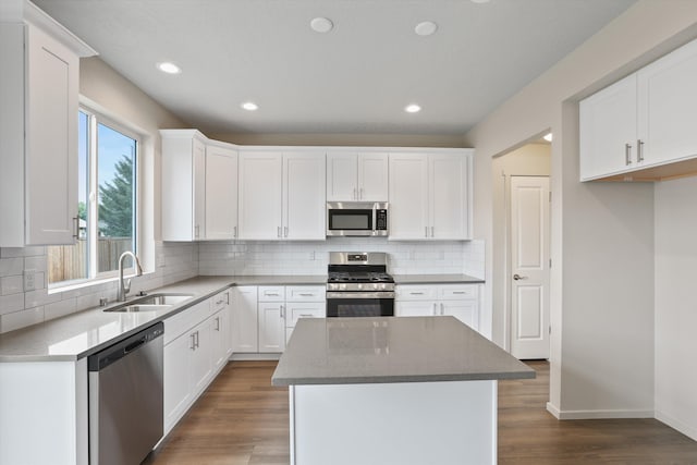 503 N Arc Ct, Spokane Valley, WA 99016 - kitchen featuring stainless steel appliances, dark wood-type flooring, a kitchen island, decorative backsplash, and white cabinetry