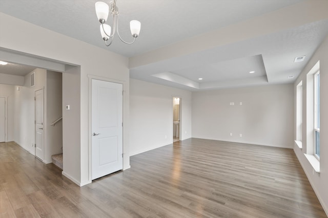503 N Arc Ct, Spokane Valley, WA 99016 - unfurnished room featuring a raised ceiling, wood finished floors, a chandelier, stairway, and recessed lighting