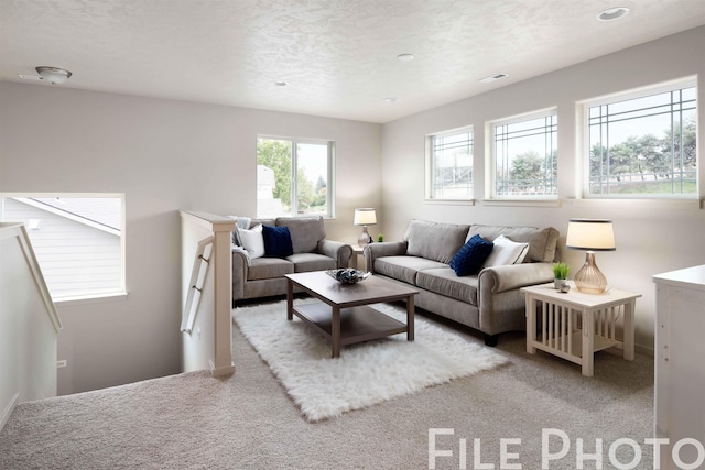 living room with visible vents, carpet floors, and a textured ceiling
