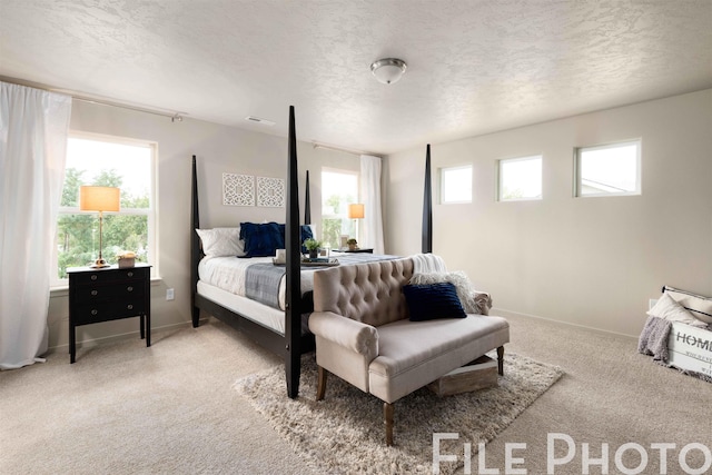 bedroom with carpet flooring, visible vents, baseboards, and a textured ceiling