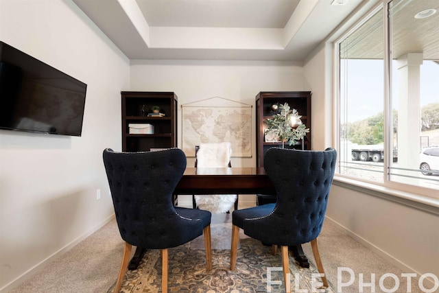 dining space featuring baseboards, carpet floors, and a raised ceiling