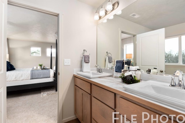 full bath with a sink, visible vents, double vanity, and ensuite bath
