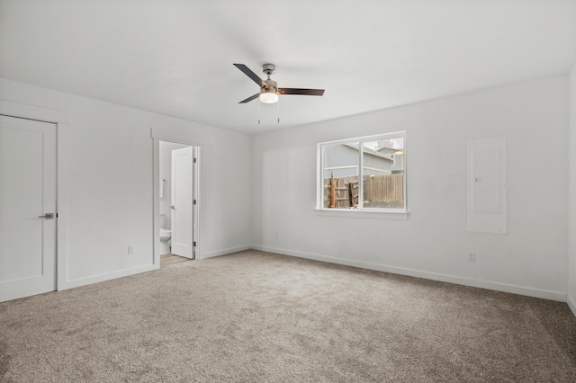 carpeted empty room with baseboards, electric panel, and a ceiling fan