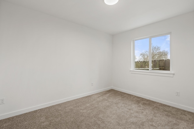 spare room with baseboards and carpet flooring