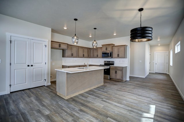 18517 E Michielli Ln, Spokane Valley, WA 99016 - kitchen featuring appliances with stainless steel finishes, a sink, light countertops, backsplash, and a center island with sink