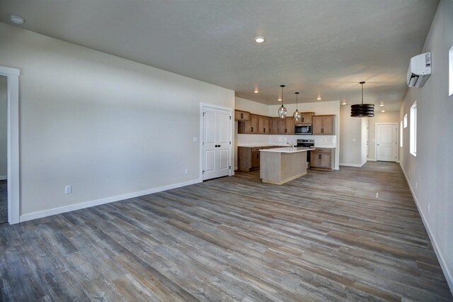 18517 E Michielli Ln, Spokane Valley, WA 99016 - kitchen featuring stainless steel appliances, open floor plan, light countertops, a center island with sink, and dark wood-style floors