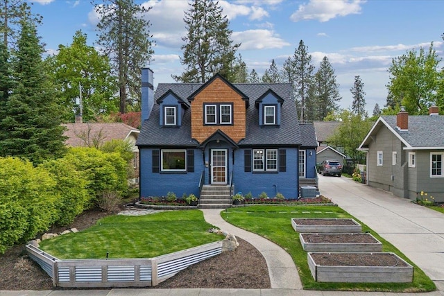 127 W 25th Ave, Spokane, WA 99203 - view of front of home with central AC, a chimney, a front yard, and a vegetable garden