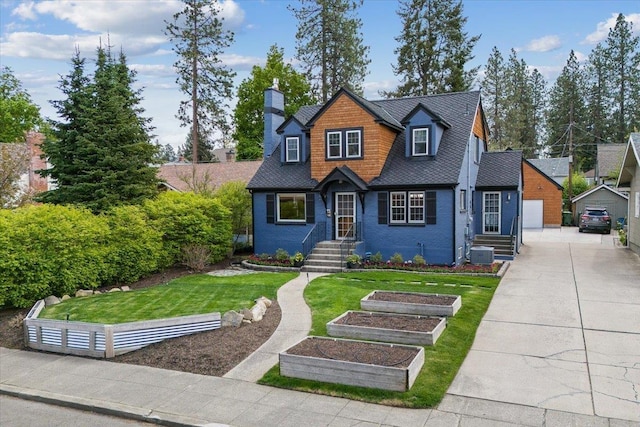 127 W 25th Ave, Spokane, WA 99203 - view of front of property with an outdoor structure, cooling unit, a front lawn, a vegetable garden, and a chimney